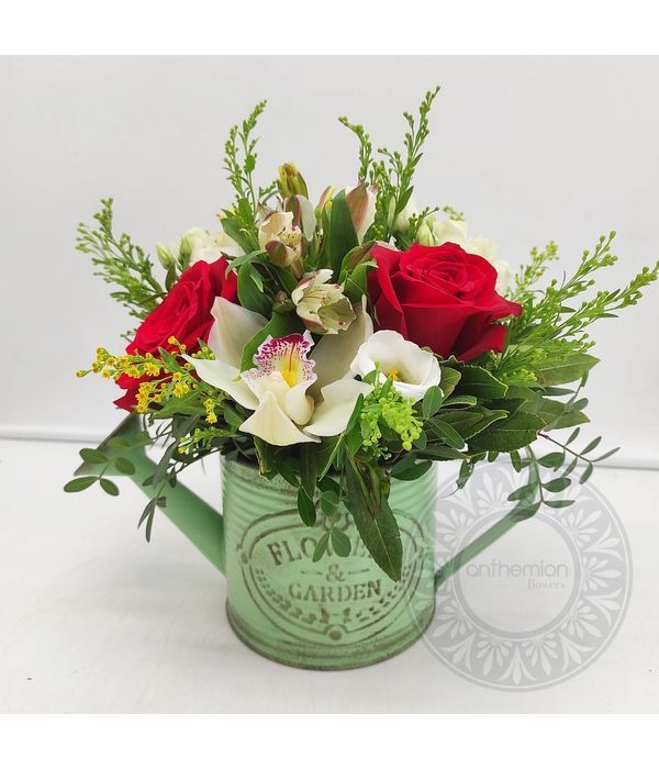 Vintage green watering can with flower arrangement