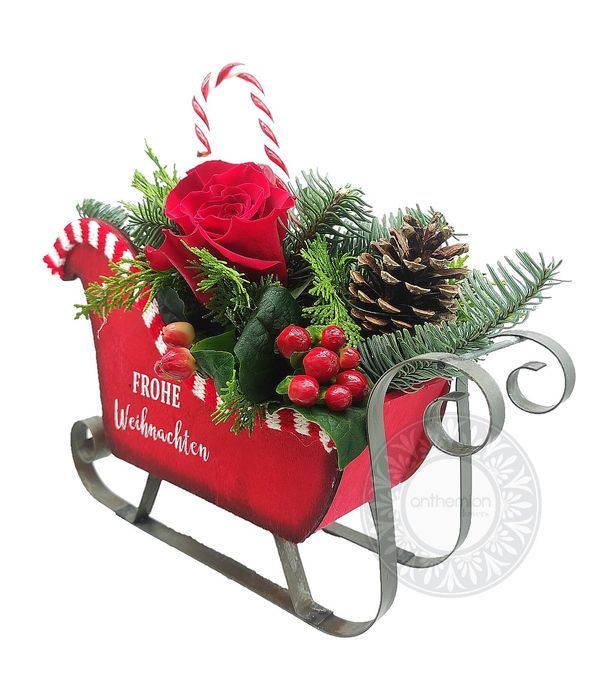 Red wooden sleigh with festive arrangement
