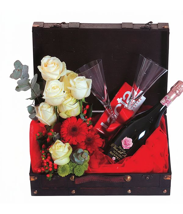 Chest with flowers sparkling wine, glasses and chocolate