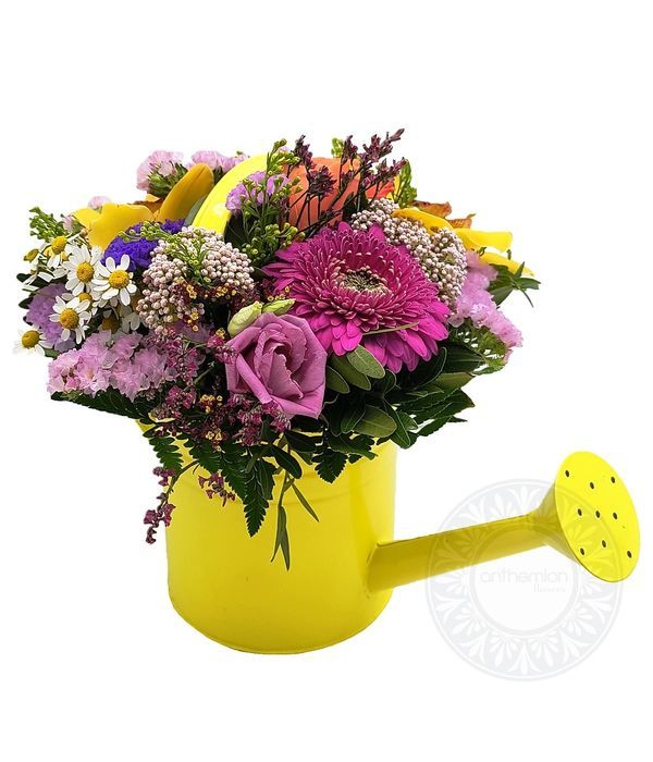 Κίτρινο ποτιστήρι με λουλούδια σε ζωηρά χρώματα