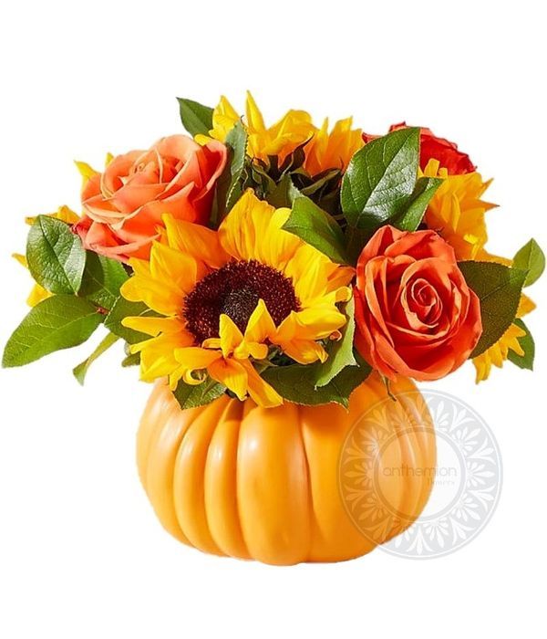 Sunflowers and orange roses in a ceramic pumpkin